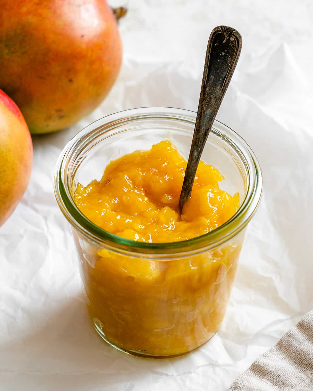 completed mango compote in a jar against a light background