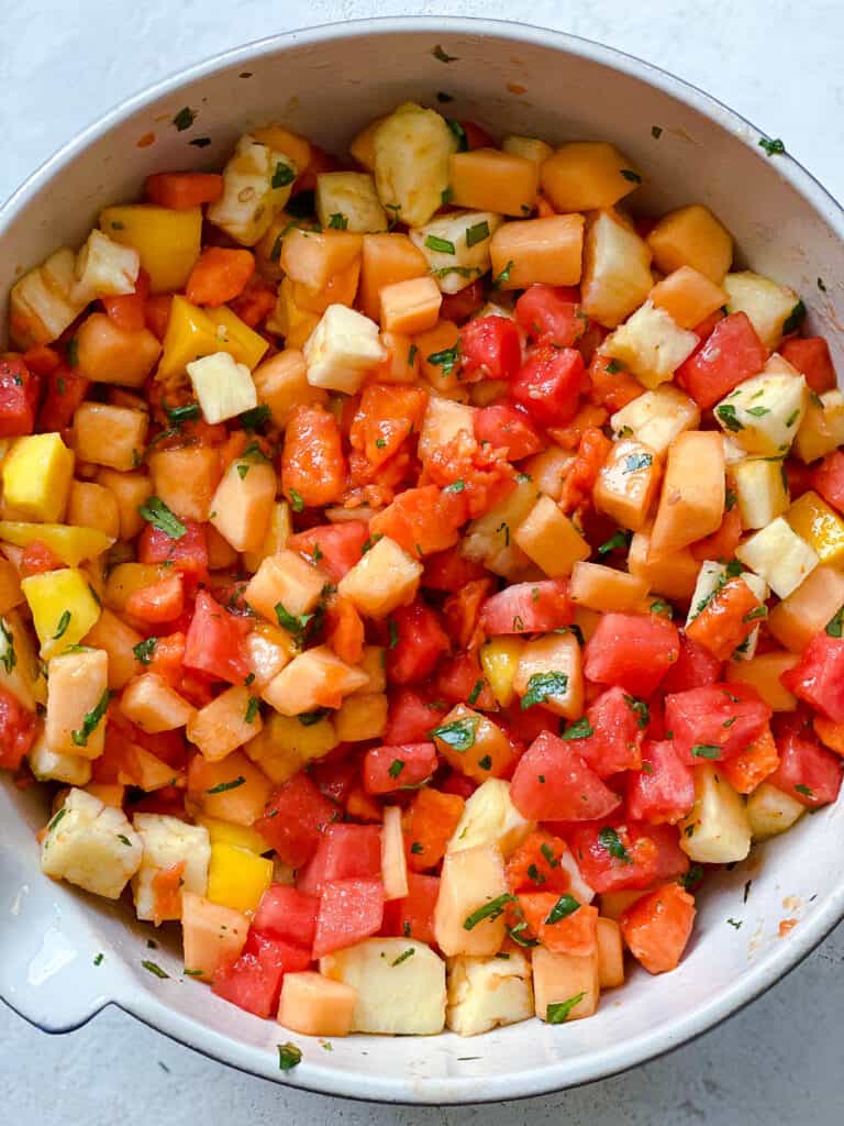 process shot showing the mixing of fruits and garnishes in bowl