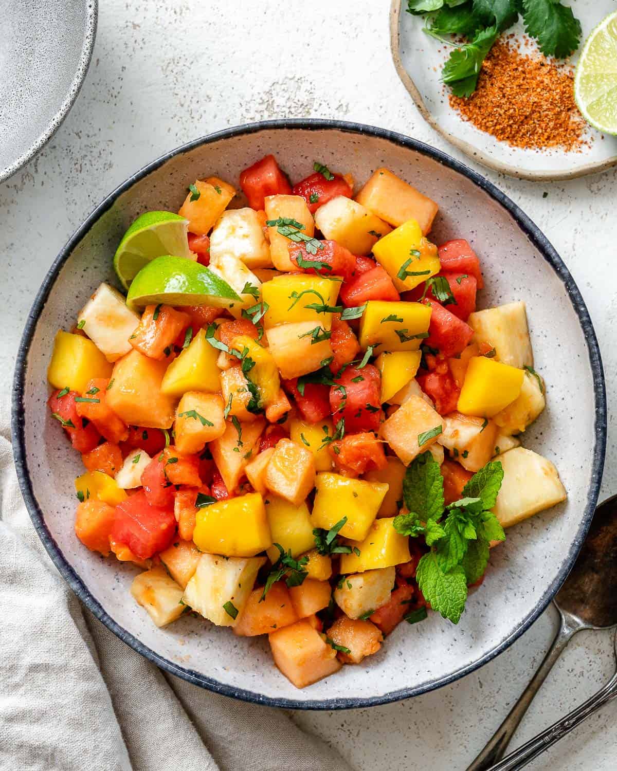 completed Mexican Fruit Salad in a bowl a،nst a white surface