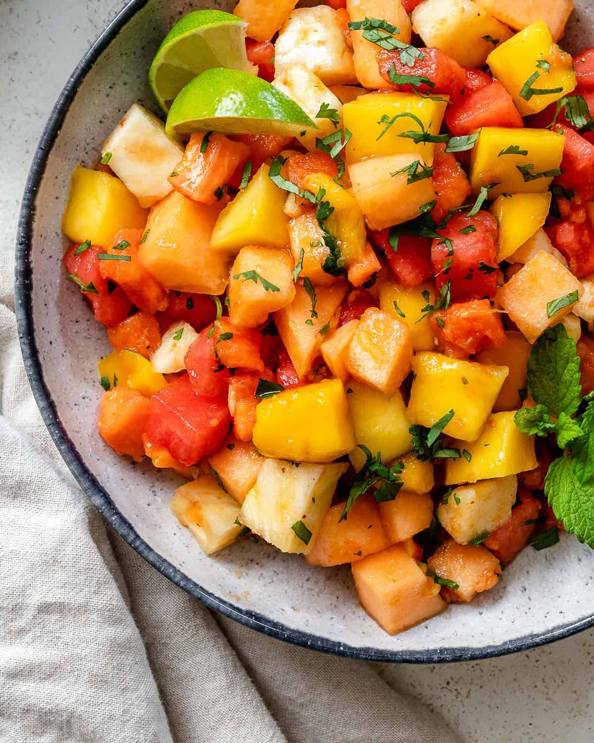 completed Mexican Fruit Salad in a bowl a،nst a white surface