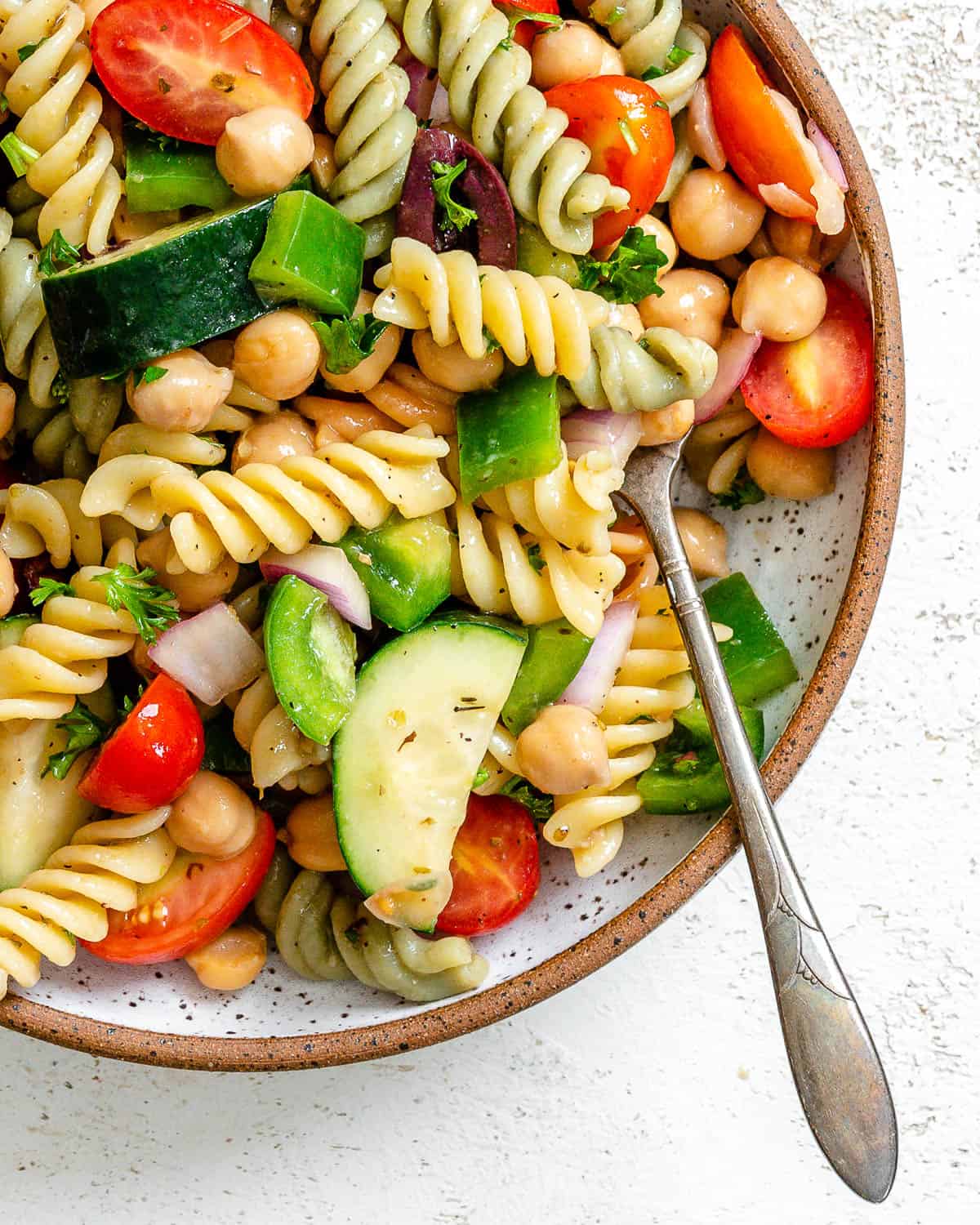 completed Mediterranean Vegan Pasta Salad plated against a white surface