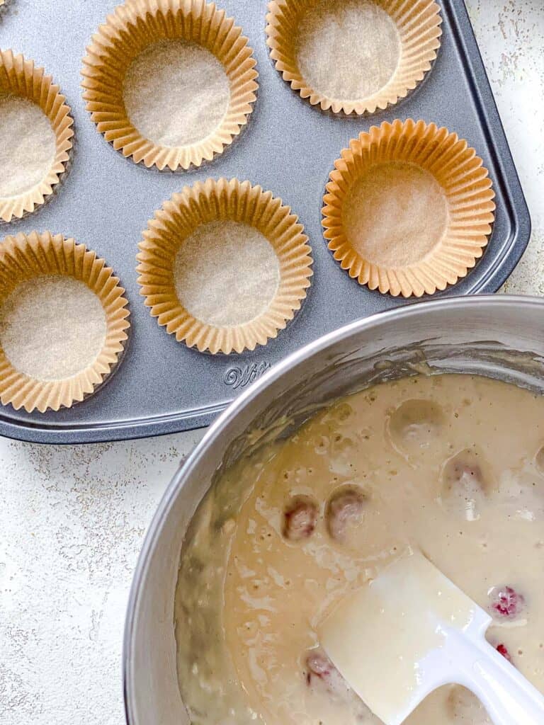process shot of adding cupcake batter to muffin tin