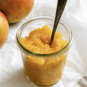 completed mango compote in a jar against a light background