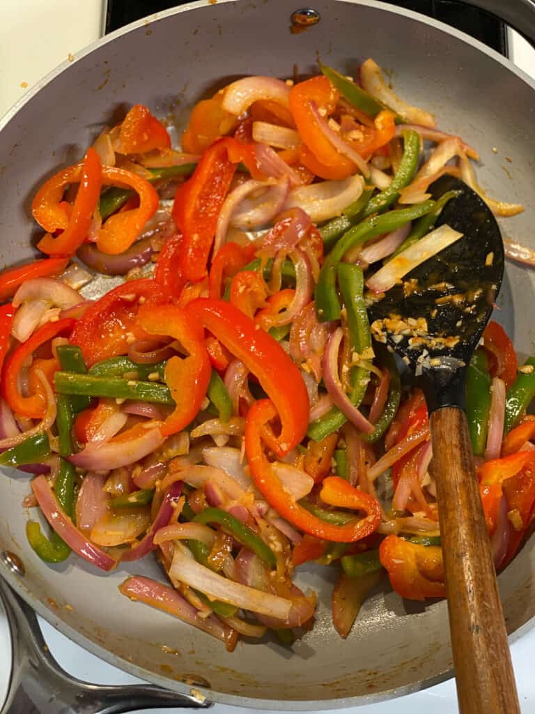 process of stirring ingredients for Vegan Fajita Tacos in pan