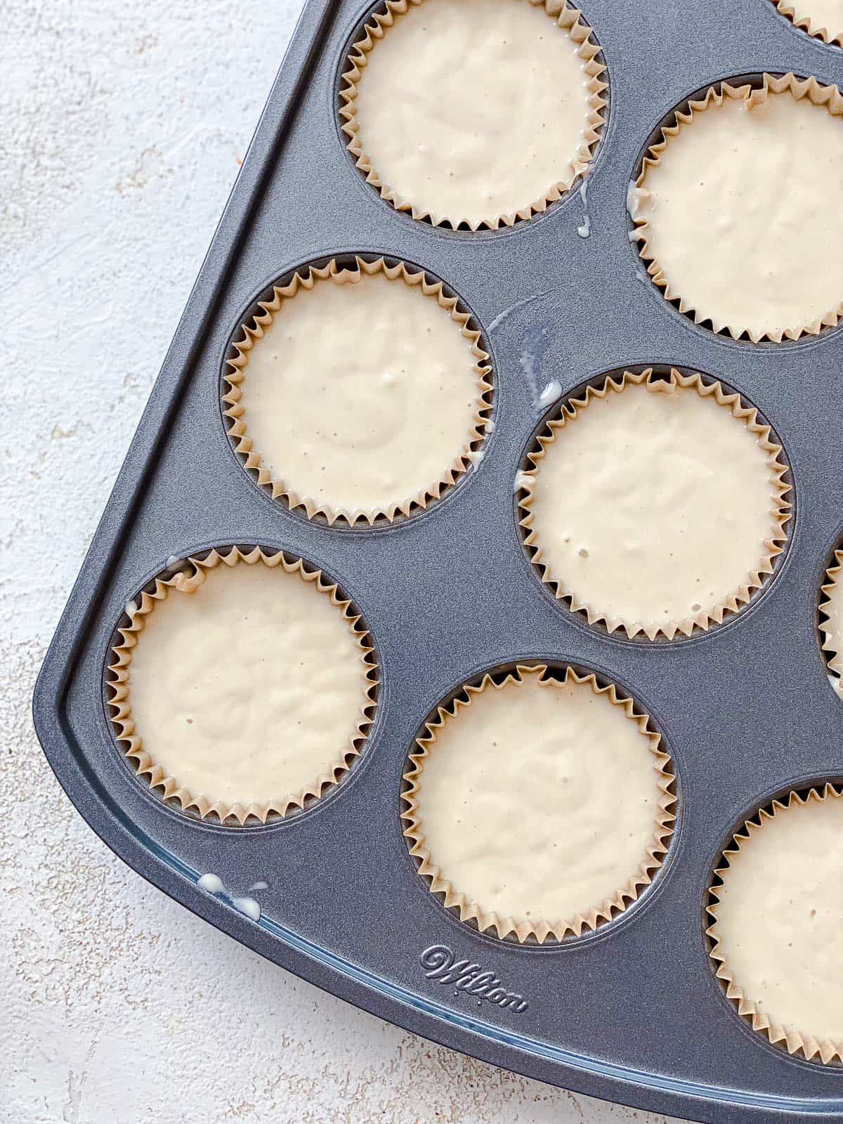 process shot showing addition of cupcake batter in muffin tin