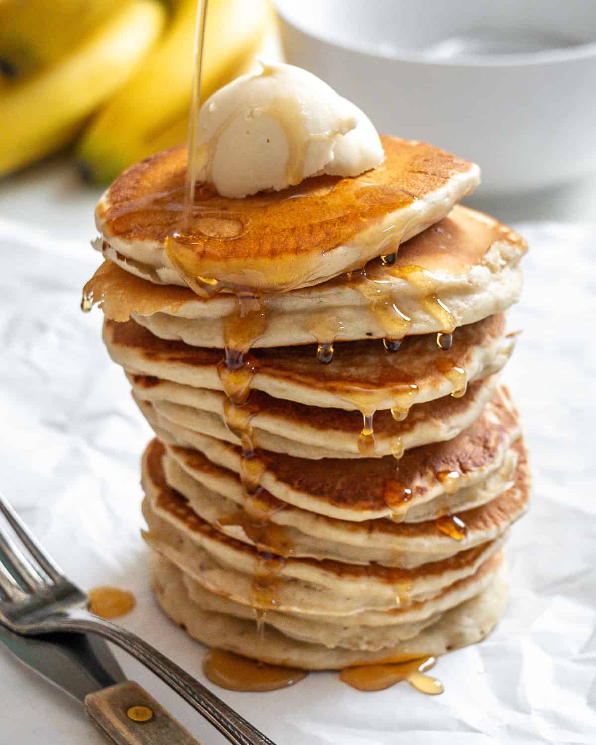 completed stack of pancakes a،nst a white surface