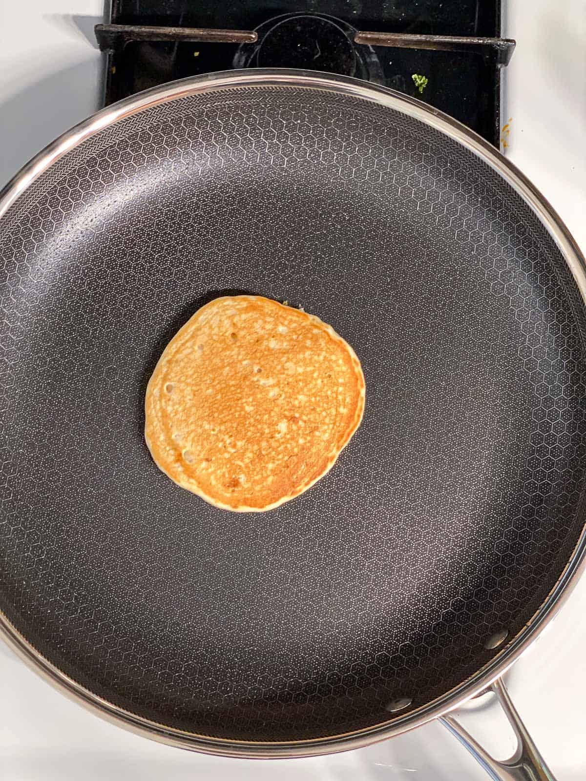 process shot showing flipped pancake on a skillet