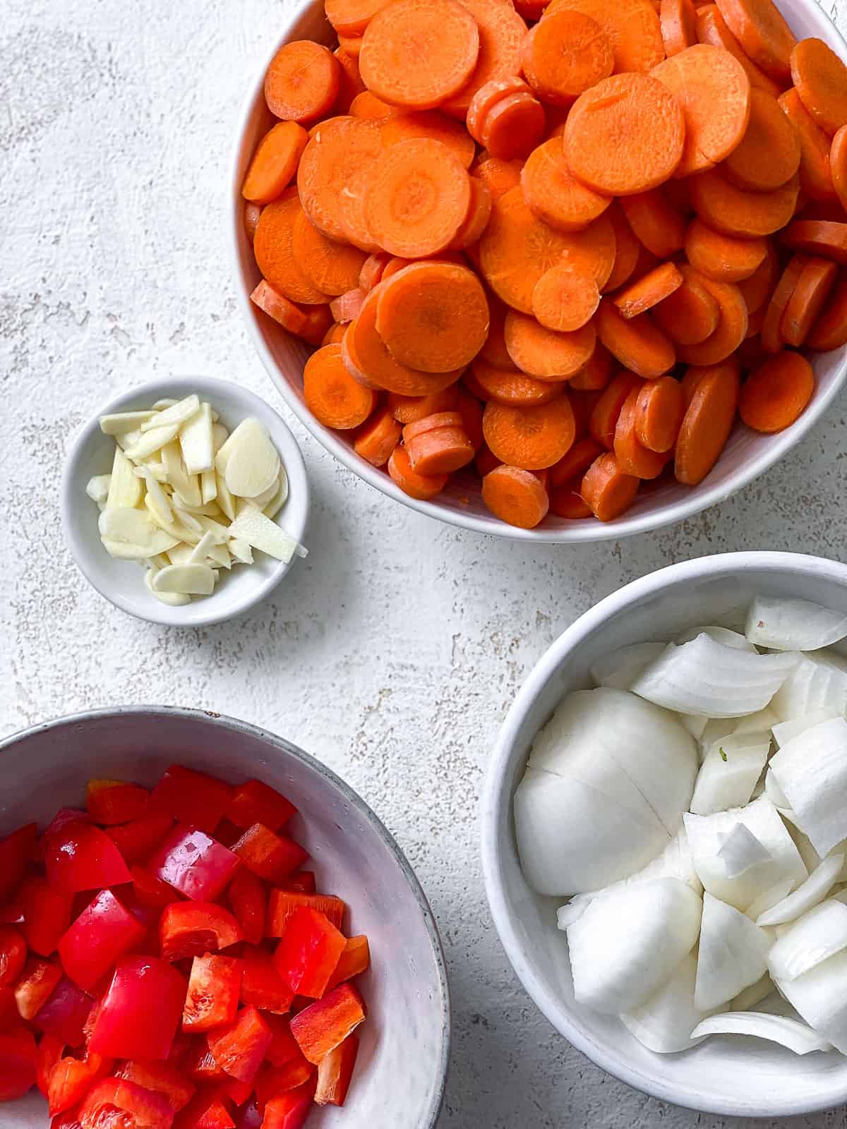 ingredients for Creamy Chickpea and Carrot Curry measured out against a white surface