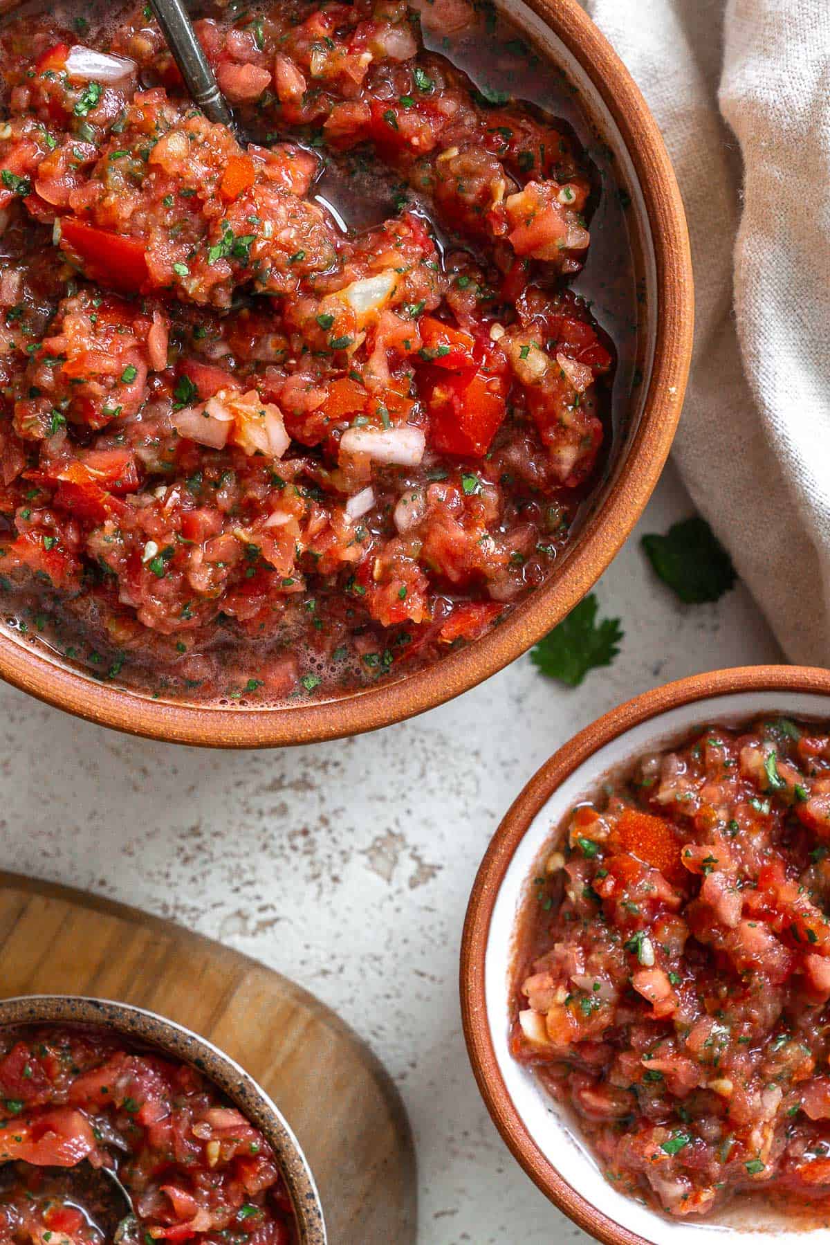 completed 5 Minute Garden Fresh Salsa in three different bowls against a white surface