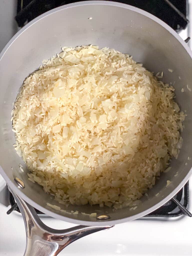 process shot of rice being mixed into pot