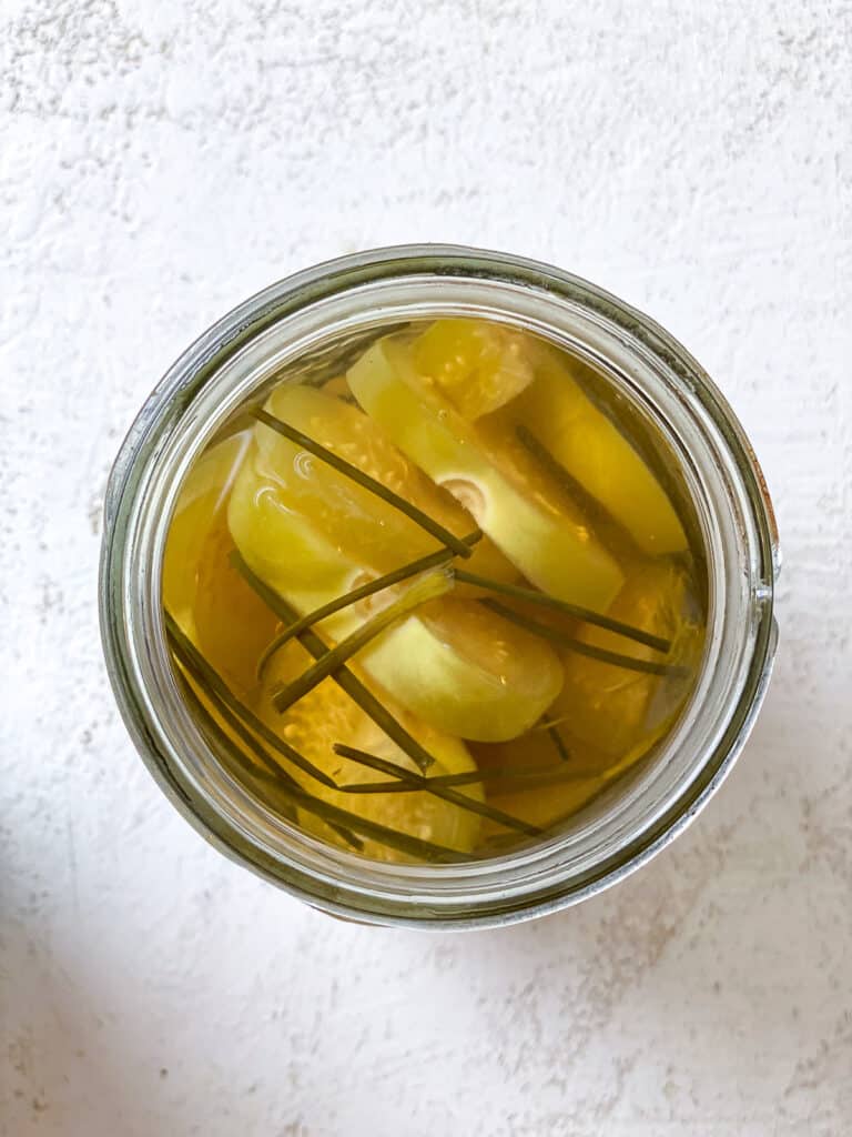 process s،t s،wing pickled green tomatoes in a jar