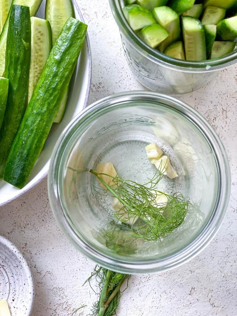 ingredients for Quick Easy Refrigerator Pickles added to glass container