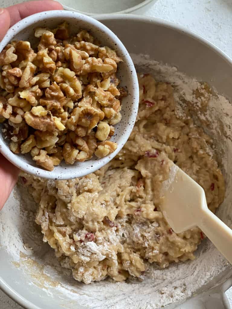 process of adding walnuts to apple muffin mixture