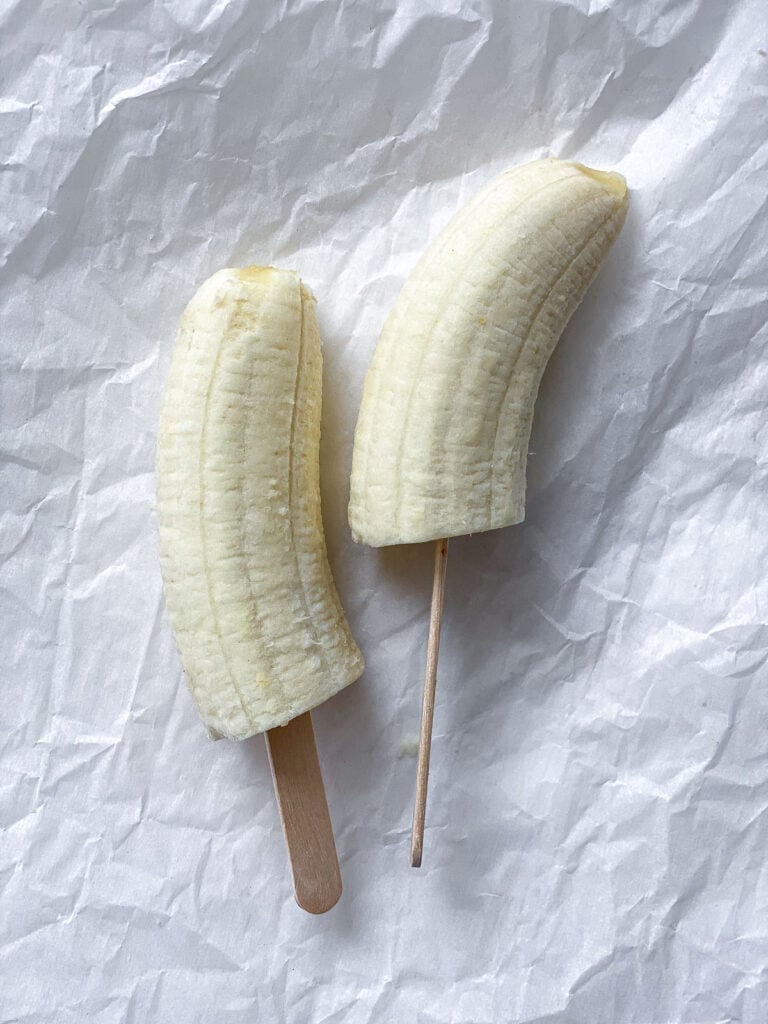 process shot of adding popsicle stick to bananas