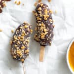completed Peanut Butter and Chocolate Covered Bananas on a white surface