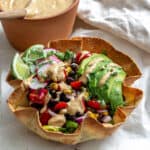completed taco salad alongside a bowl of taco salad dressing