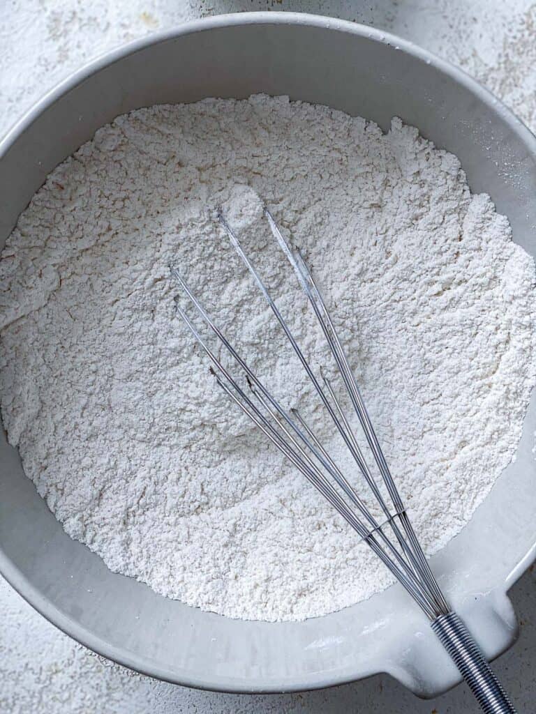 process s،t of whisking ingredients together in bowl