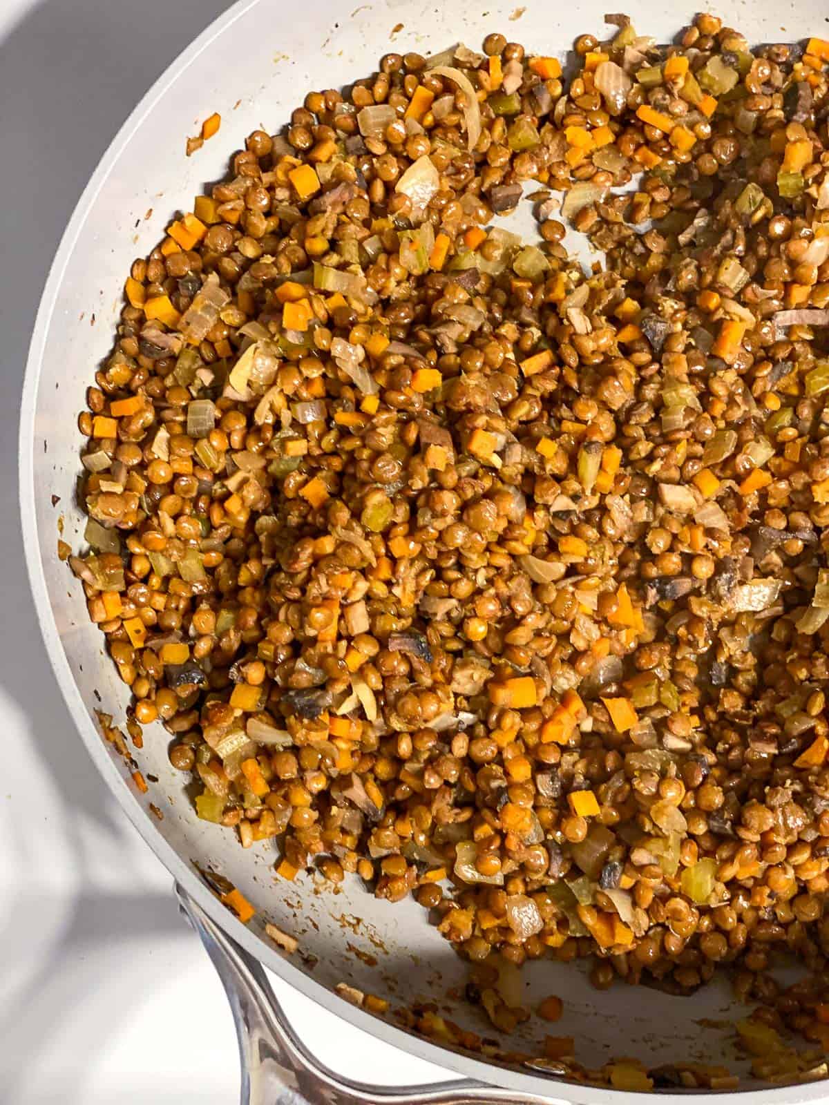 Cooked lentil and vegetable filling in a skillet.