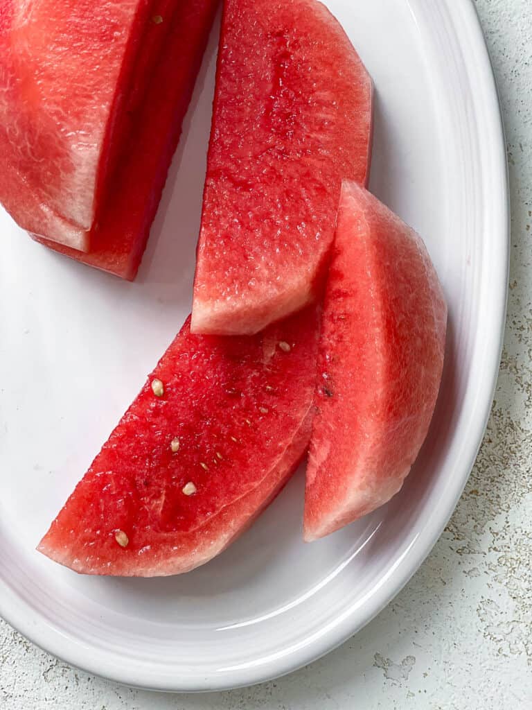sliced watermelon on a white platter