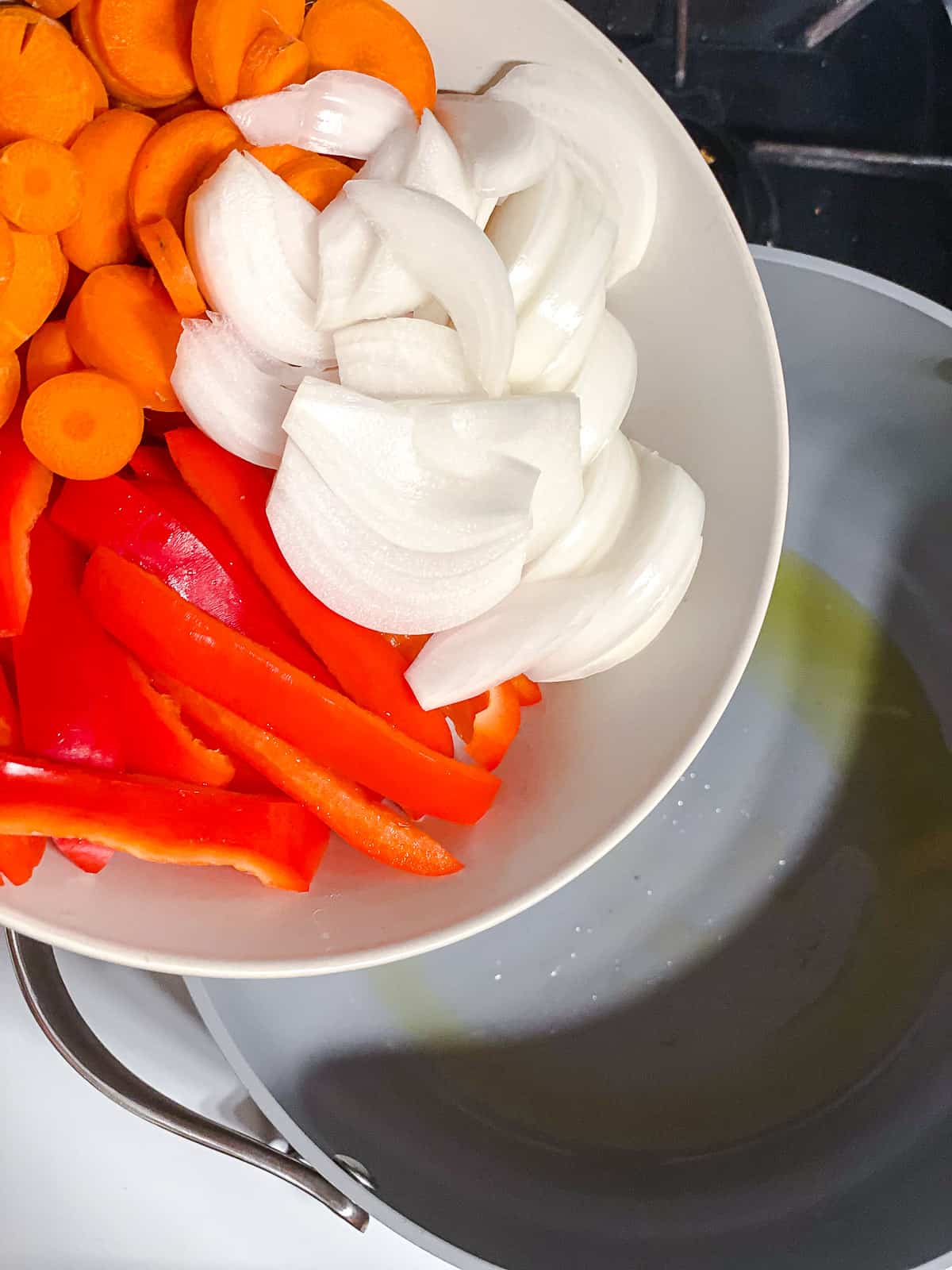 Adding all the veggies to a pot with oil.