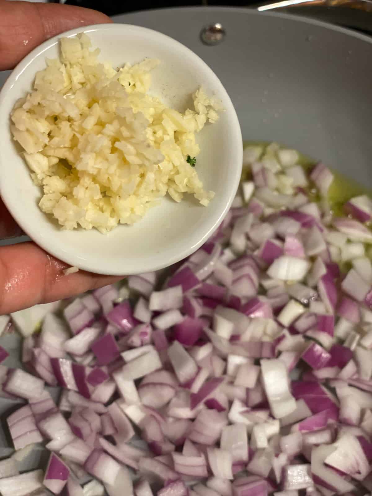 process shot of garlic being added to pan