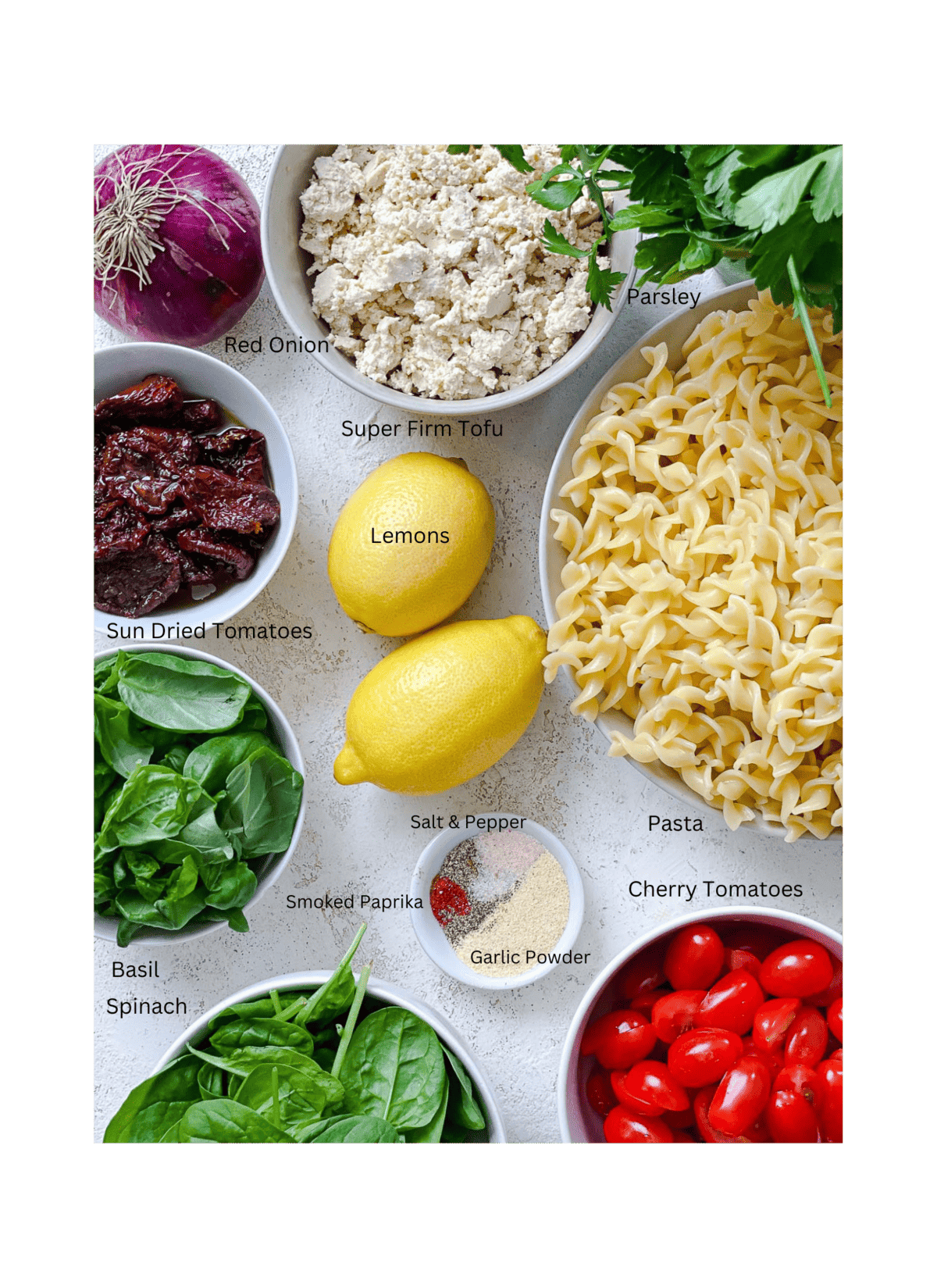 ingredients for sun dried tomato pasta salad measured out a،nst a white surface
