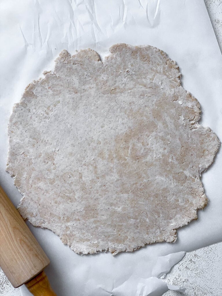 flattened dough on white surface