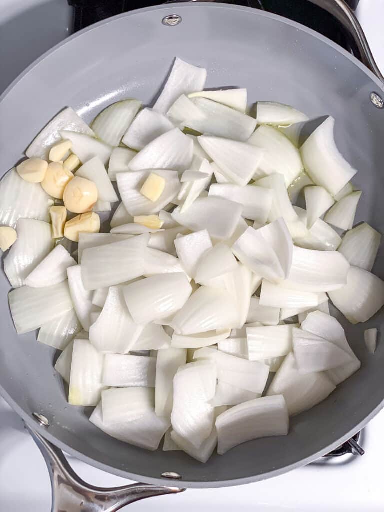 process shot of onions and garlic cooking in pan