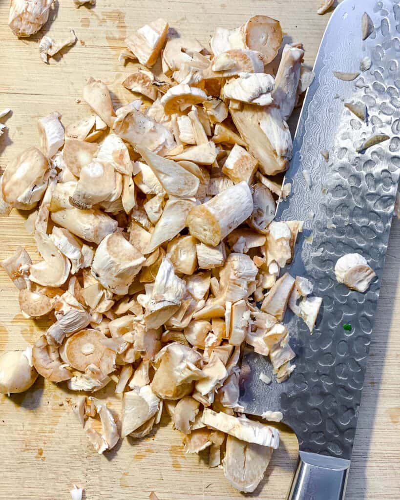 process shot of cutting mushrooms on cutting board