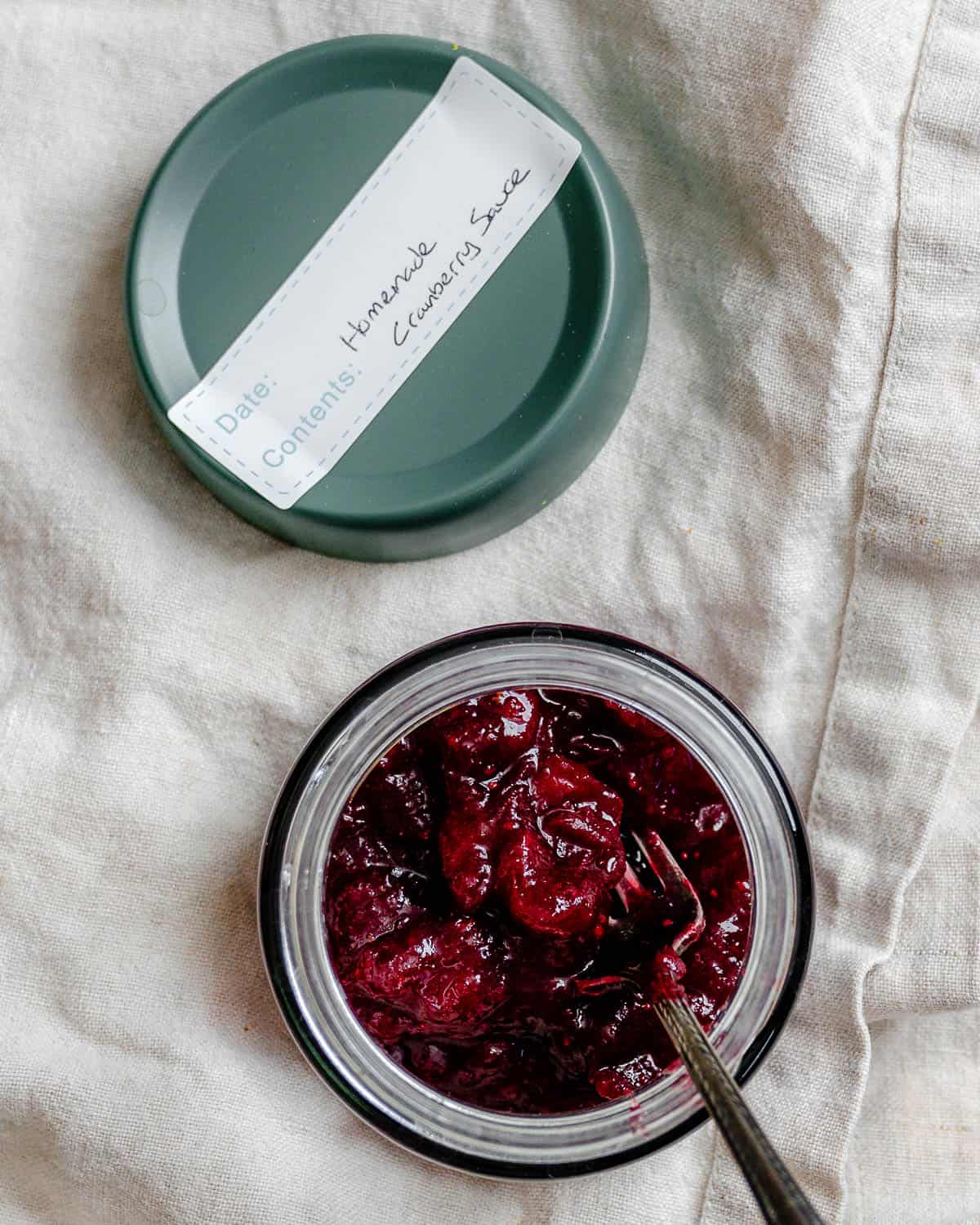 Easy Cranberry Sauce with Orange Juice in a storage container on a white surface