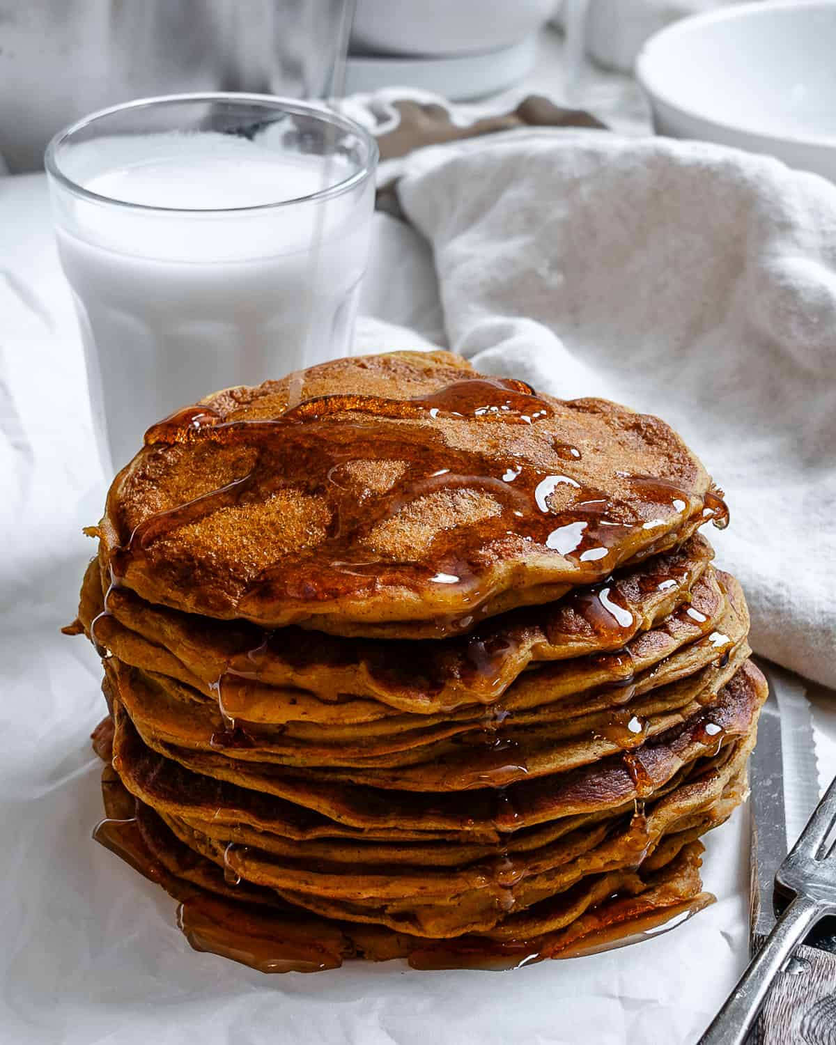 completed Easy Vegan Pumpkin Pancakes on a white surface