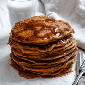 completed Easy Vegan Pumpkin Pancakes on a white surface