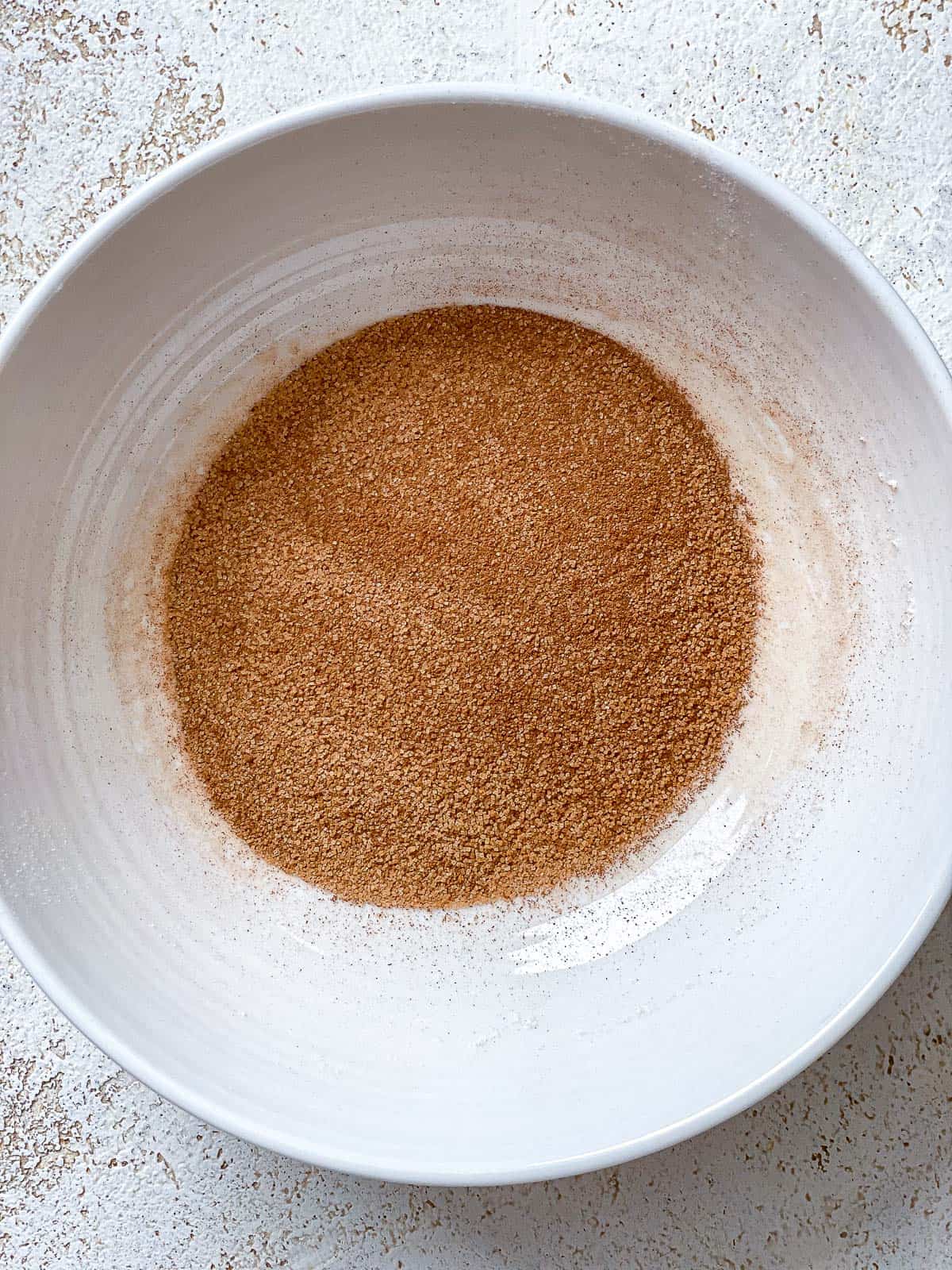 Cinnamon sugar coating mixed in a small white bowl.