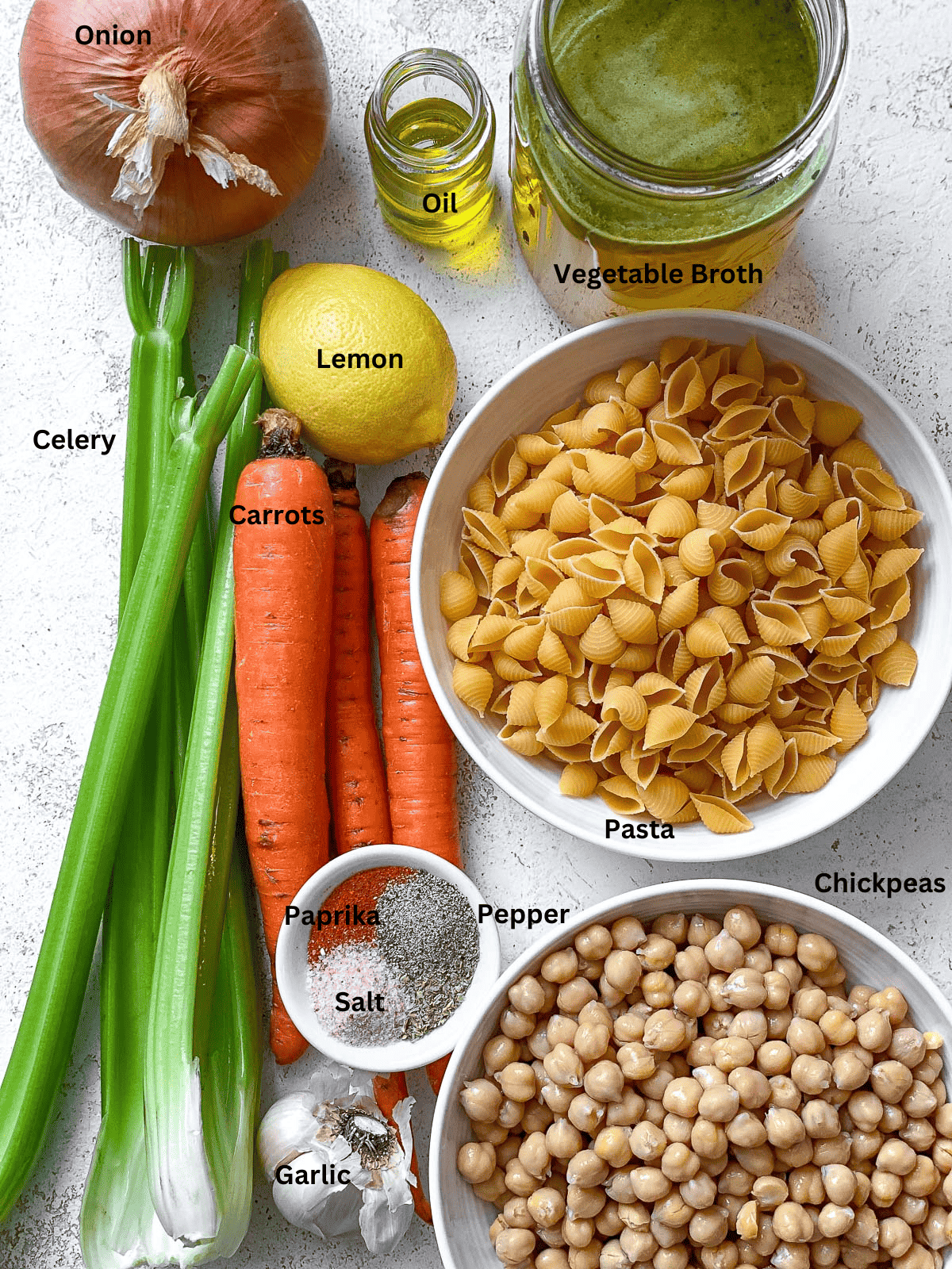 ingredients for chickpea noodle soup on a white surface