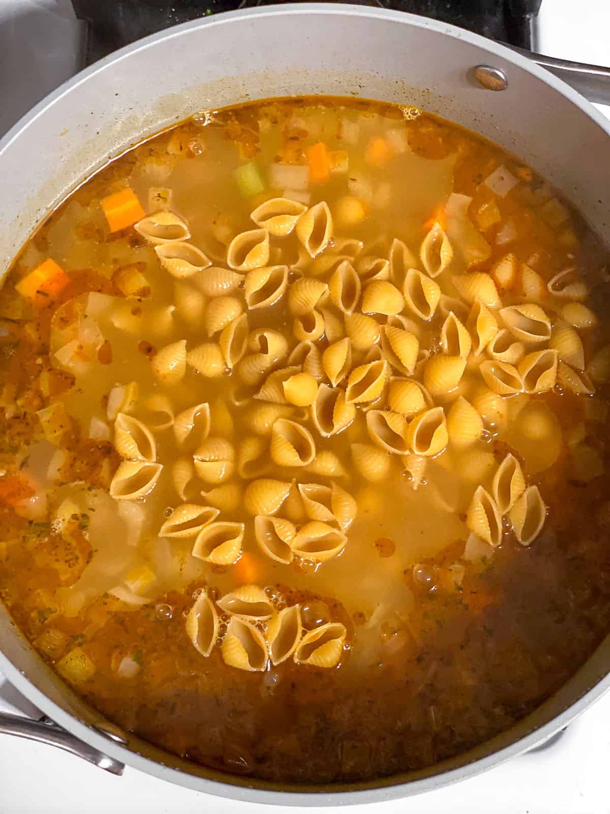 process shot of pasta added to pot