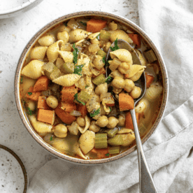 completed Vegan Chickpea Noodle Soup [Stove + Crockpot] in two bowls on a white surface