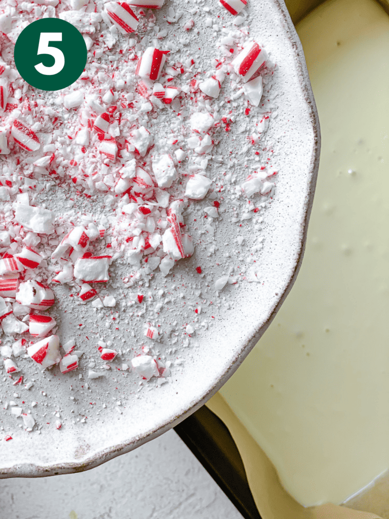 process shot of adding crushed candy canes to pan