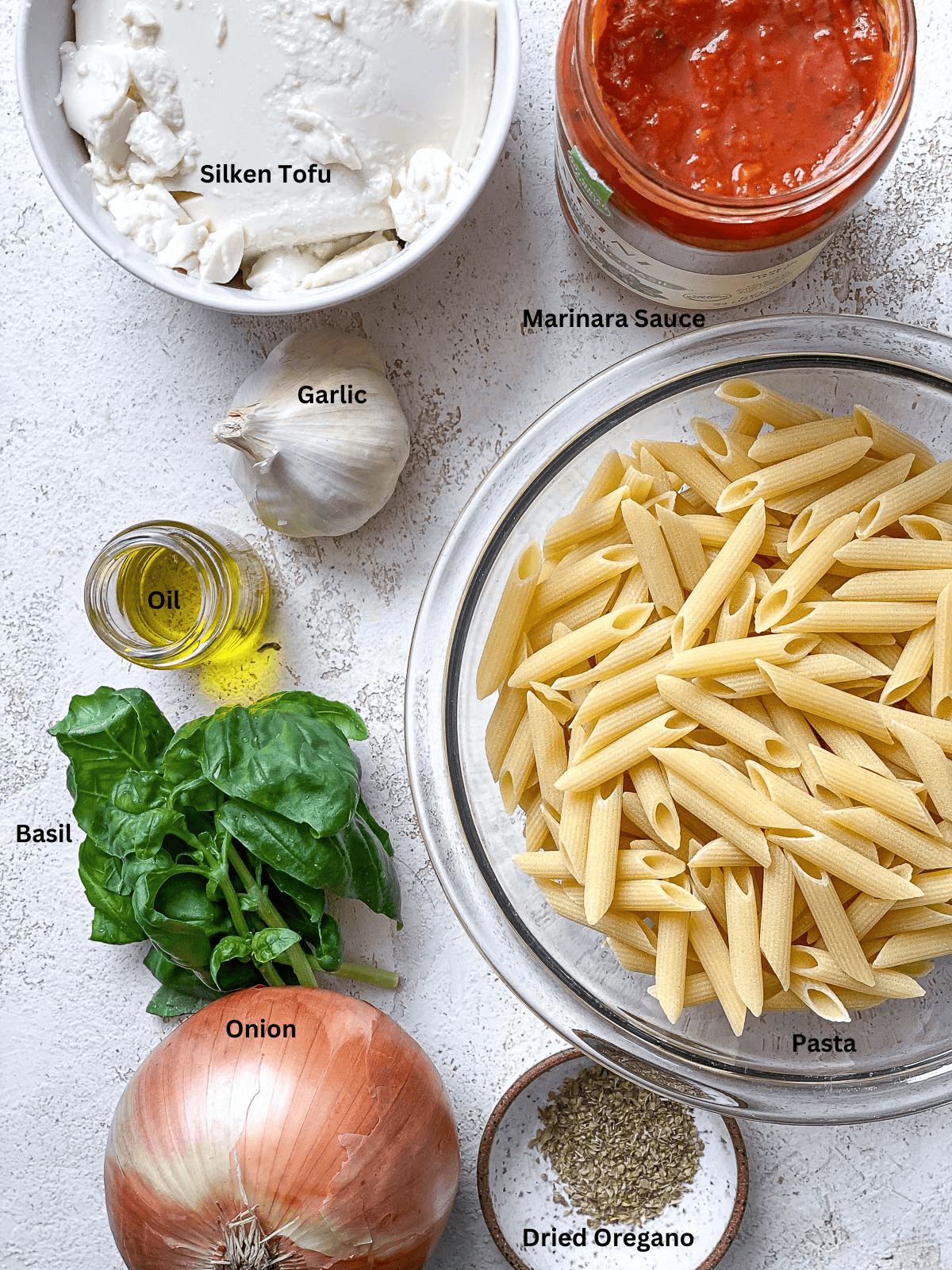 ingredients for Creamy Tomato Tofu Pasta Sauce on a white surface