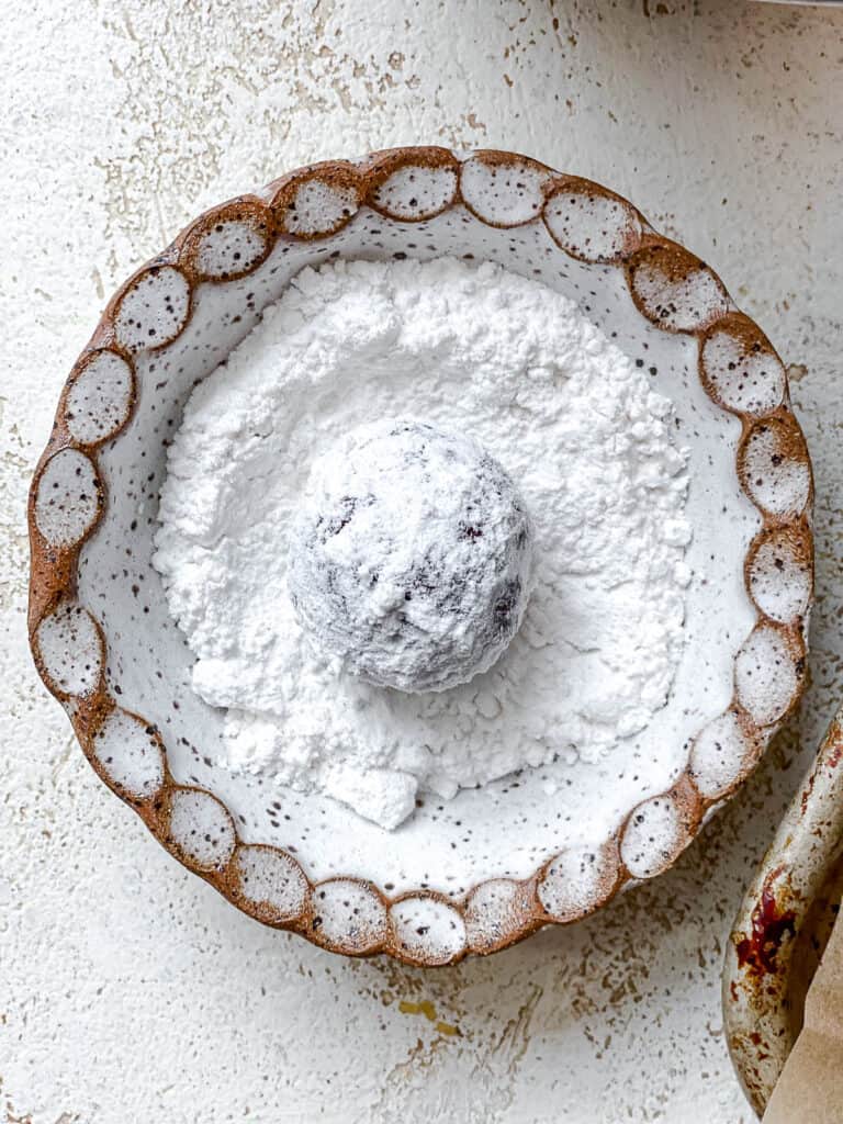 process shot showing adding dough to bowl of sugar