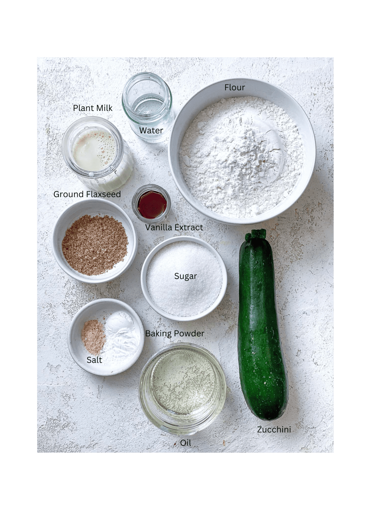ingredients for Easy Vegan Zucchini Muffins measured out against a white surface