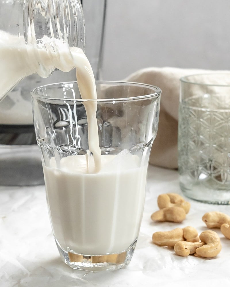 completed Cashew Milk being poured into a gl،