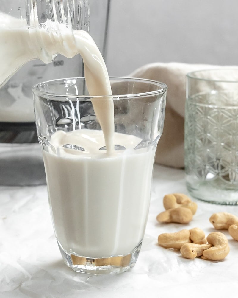 completed Cashew Milk being poured into a gl،