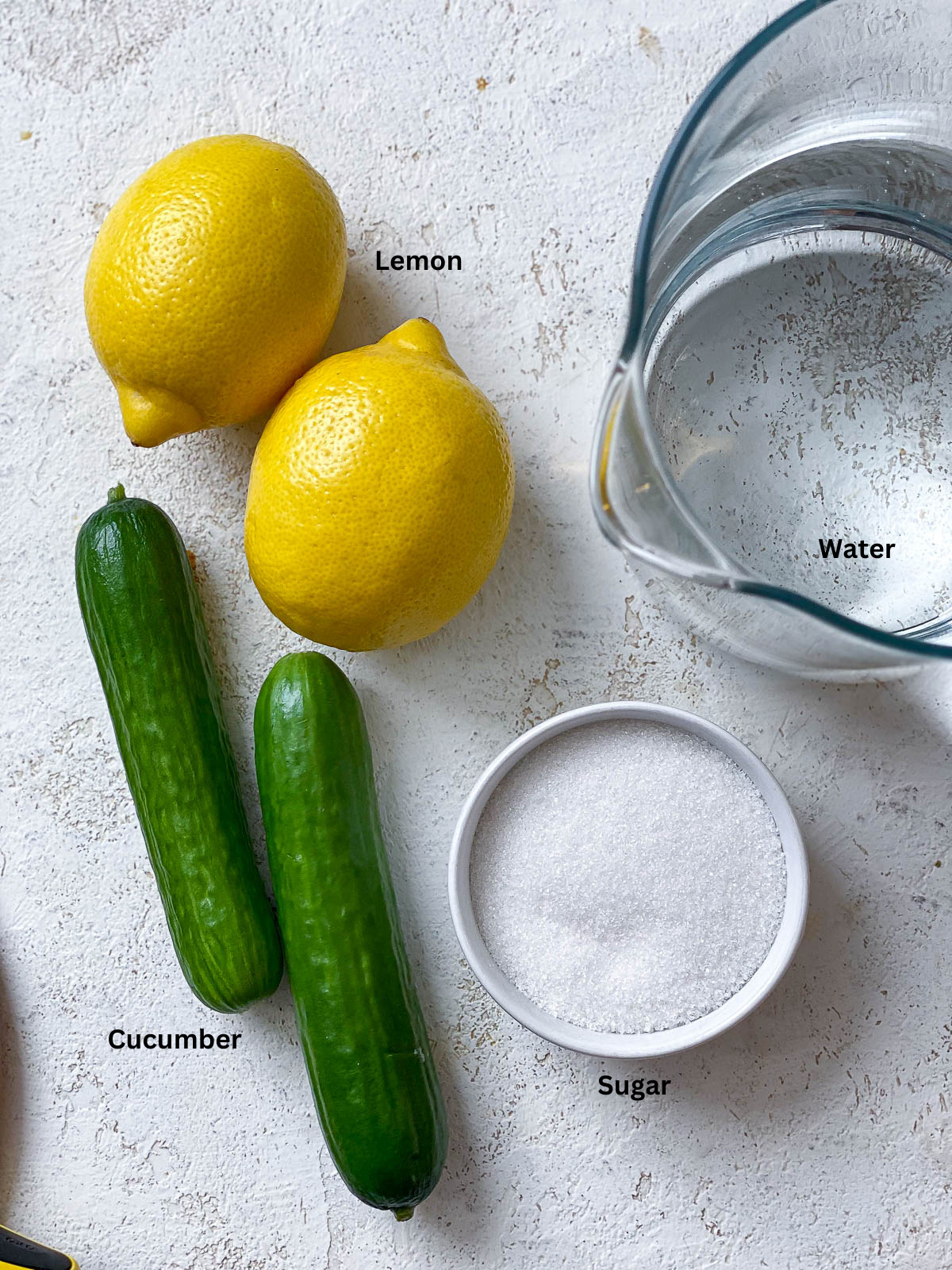 ingredients for Cucumber Lemonade measured out on a white surface