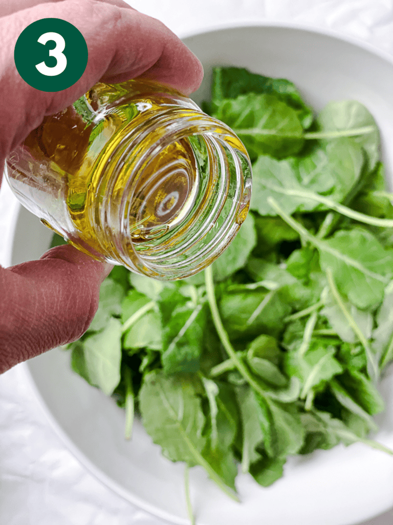 process s،t of adding olive oil to greens
