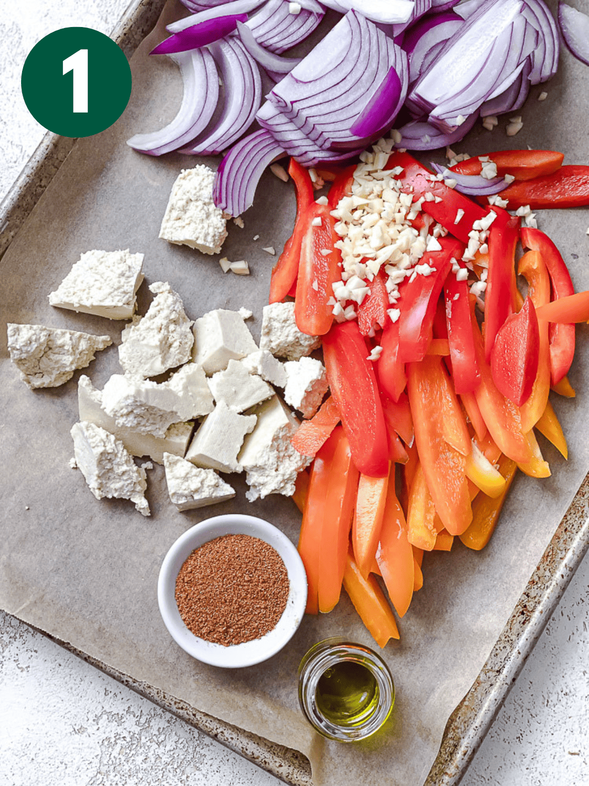 ingredients for tofu fajitas on a parchment-lined baking sheet.