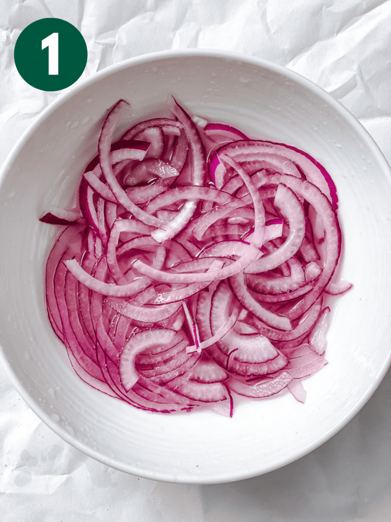 process shot showing sliced onions in a bowl