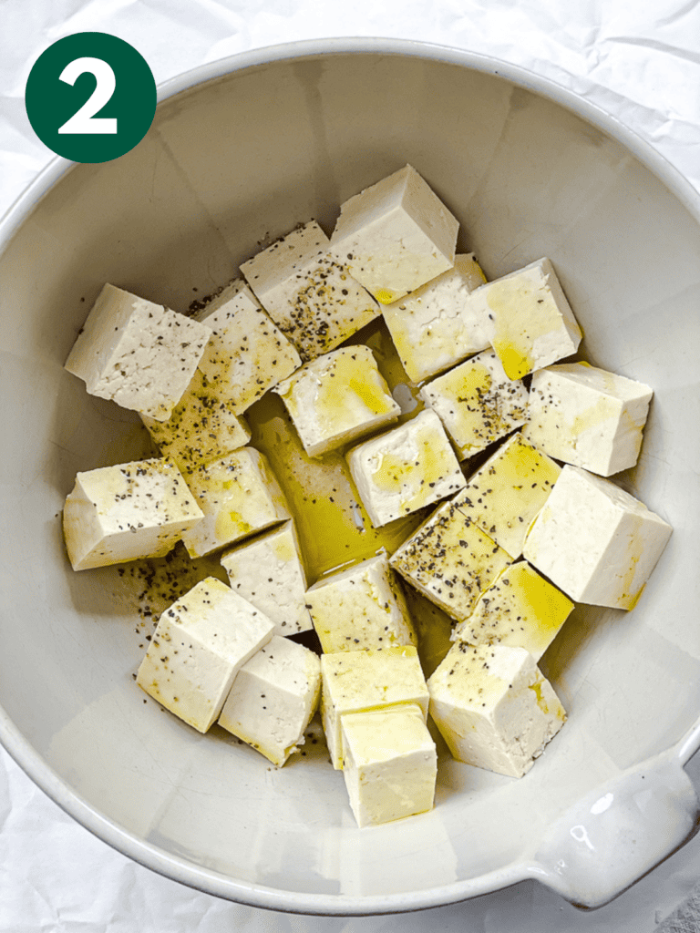 process shot showing tofu with seasoning in a bowl