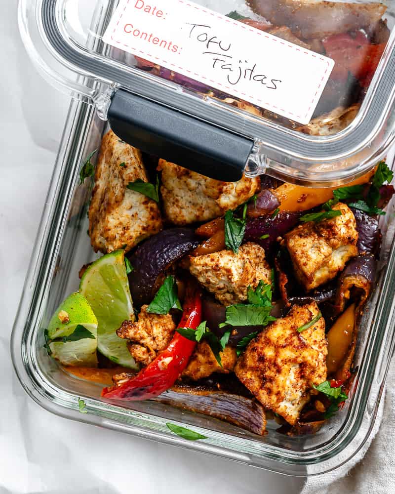 cooked peppers and tofu in a glass storage container.