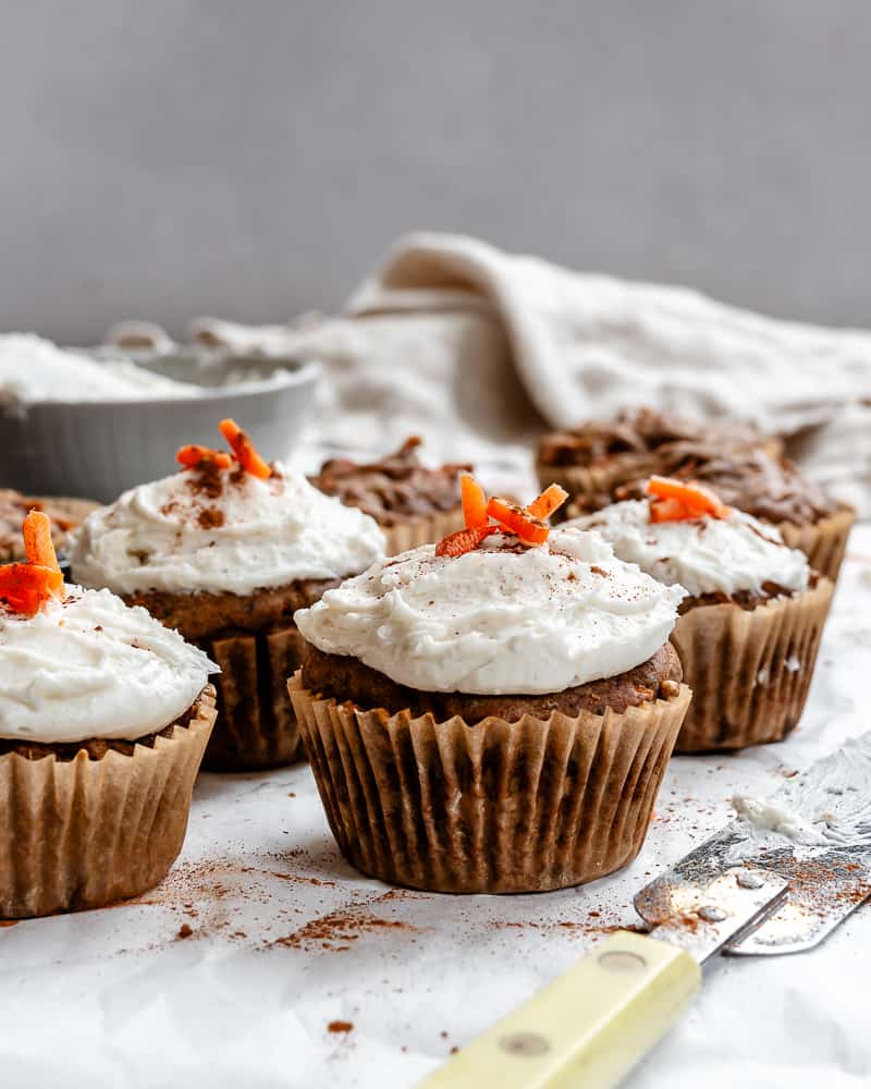 several completed Easy Carrot Cupcakes on a white surface