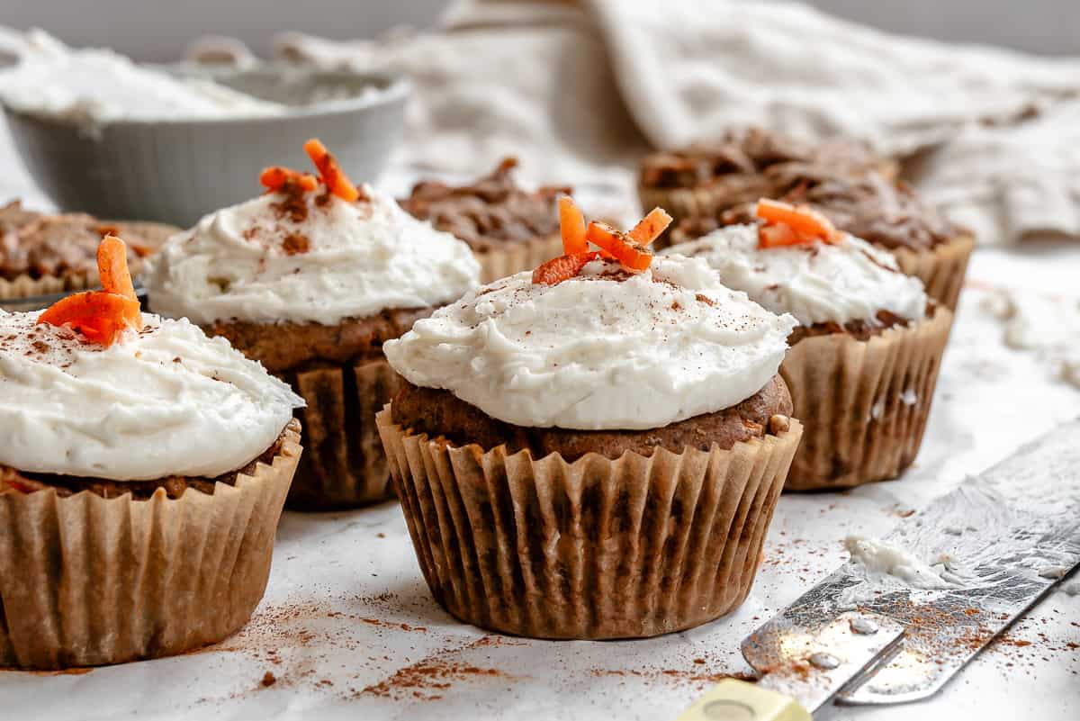 several completed Easy Carrot Cupcakes on a white surface